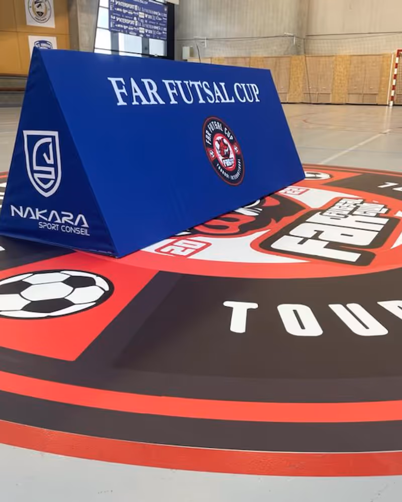Panneau publicitaire toblerone triangulaire en bord de terrain de sport