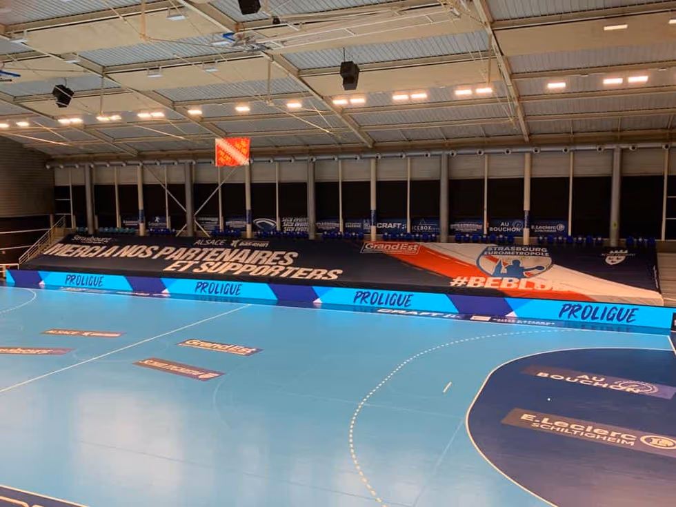 Tribunes d'une salle de handball habillées d'une bâche « Espaces partenaires » — Strasbourg Eurométropole, Nakara Sport