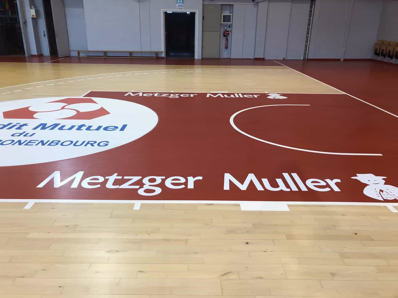 Stickers de sol et marquage publicitaire sur un parquet de basket