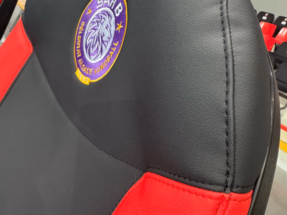 Logo SAHB Sélestat brodé sur la sellerie rouge et noir — banc de touche nu-seat handball D1
