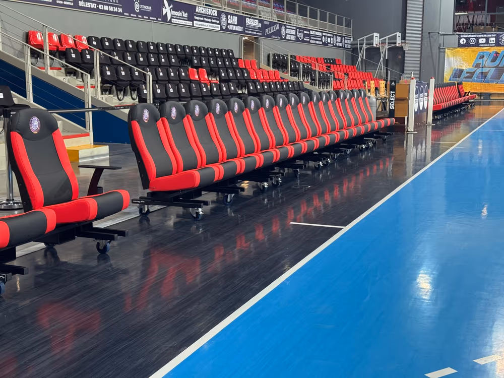 Banc de touche nu-seat rouge et noir en bord de terrain bleu — SAHB Sélestat handball D1