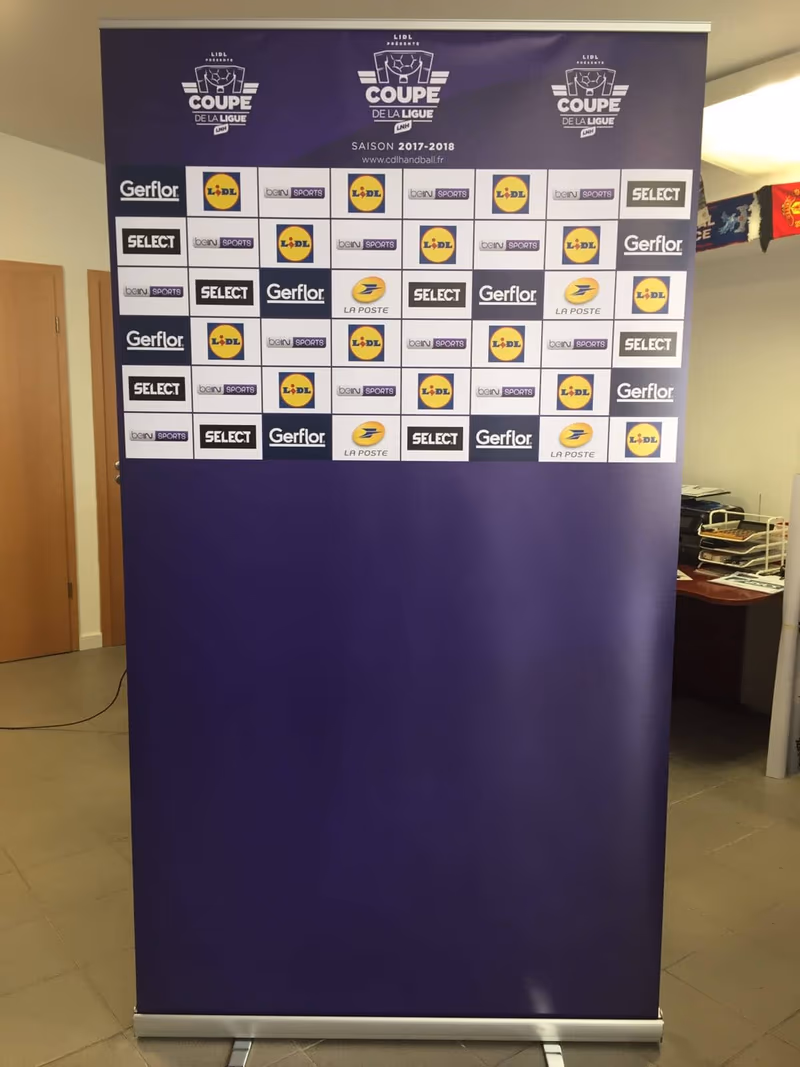 Press wall LNH handball : joueur en conférence de presse devant le mur d'interview aux logos de la ligue