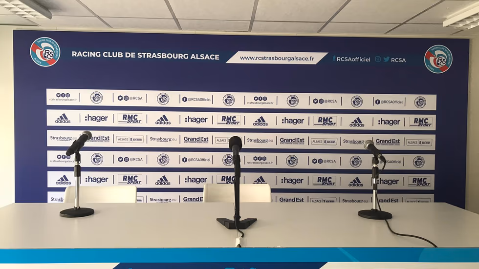 Mur d'interview de football professionnel en Ligue 1, joueur face aux micros de presse en zone mixte